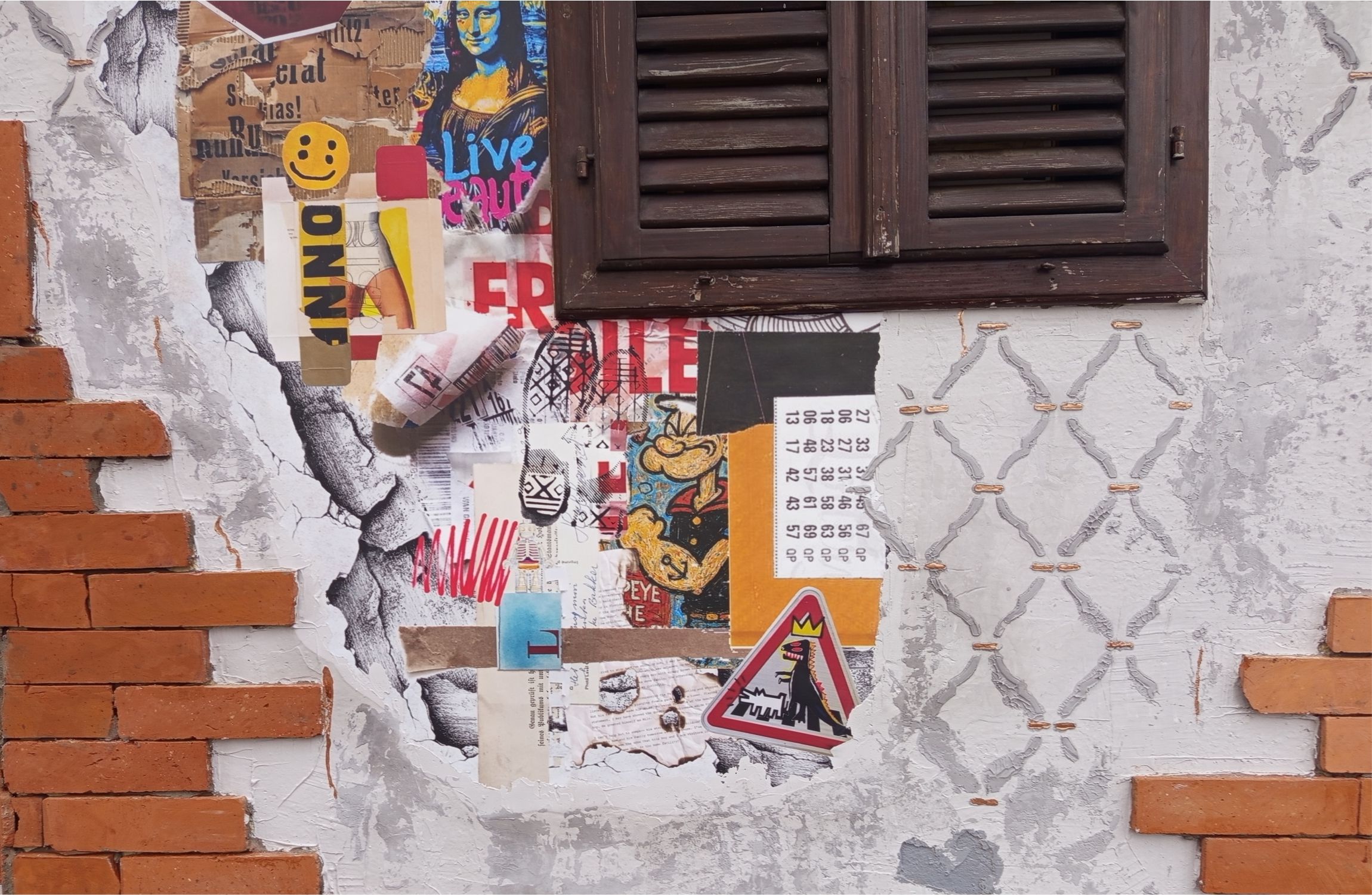 Homlokzati fal részlet, téglával, máló vakolattal és tépett hatású poszterekkel