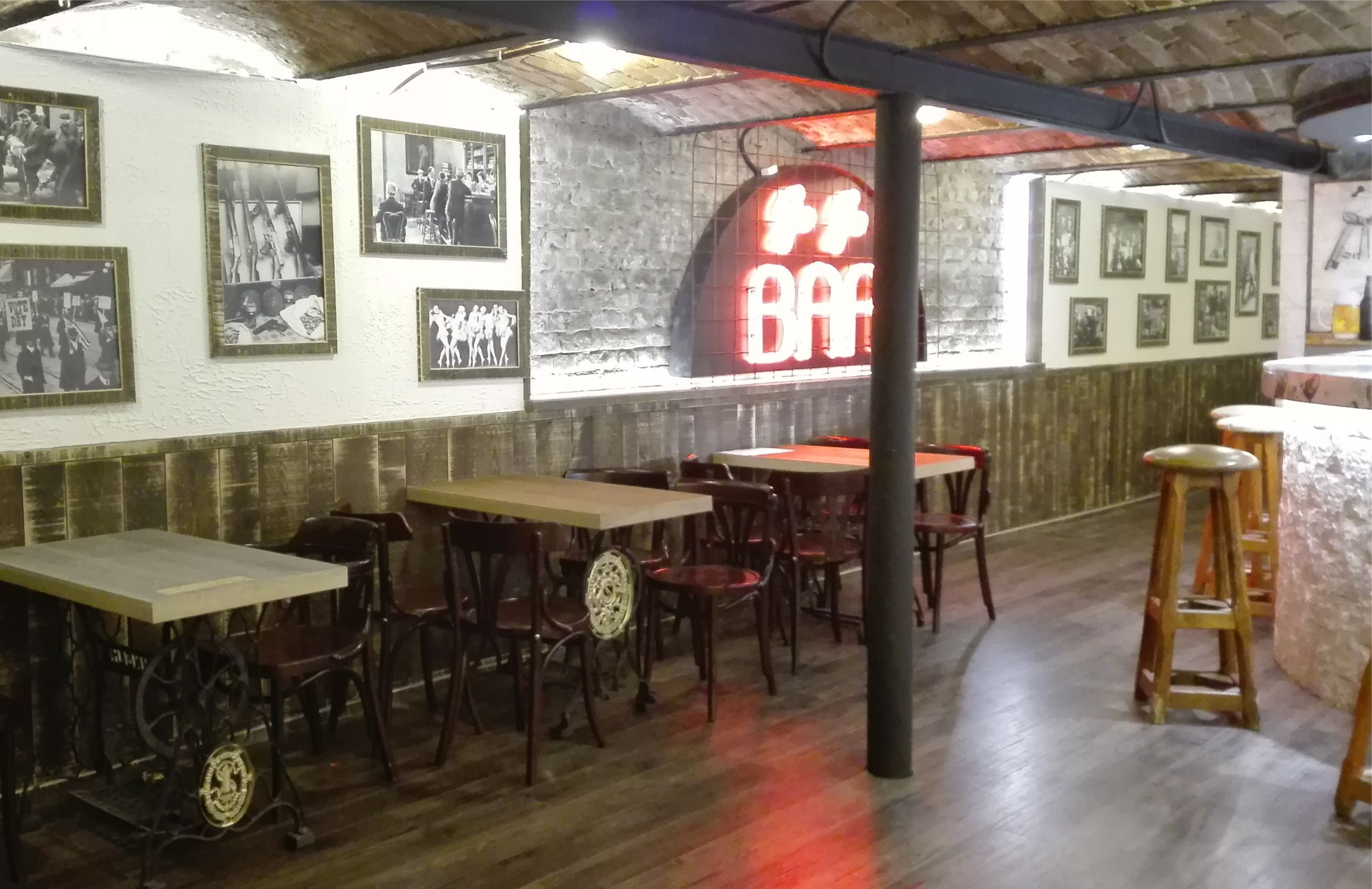 boltíves pincehelyiség, világitó bár felirattal, fa és fém bútorokkal