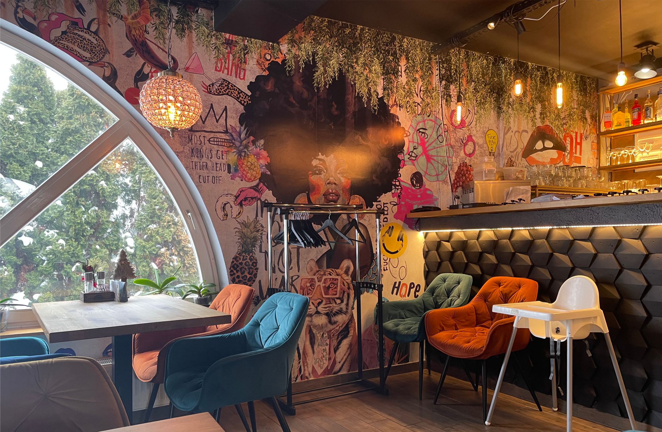 kék és narancs fotel mögött urbanart tapétával, lampion lámpával