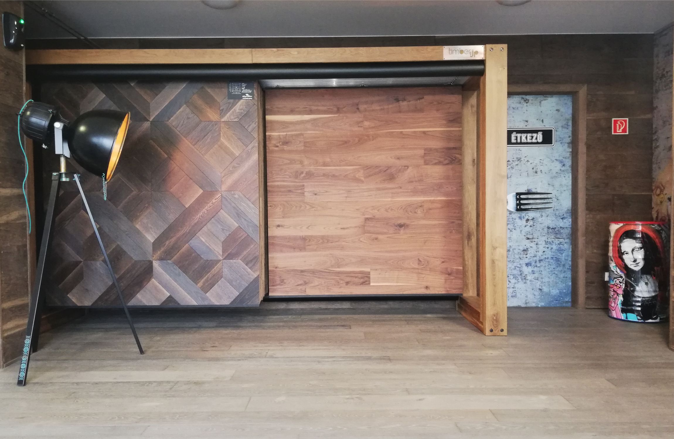 Étkező bejárata, az ajtón nagy villával, mellette monalisa a szemetesen és nagyméretű fém tripodlámpa