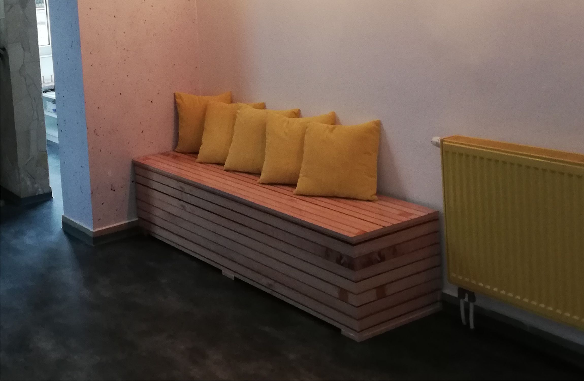 világos fa ülődoboz, sárga párnákkal